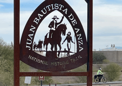 Image shows a sign that indicates that the park is part of the Juan Bautista De Anza National Trail along the Santa Cruz River.