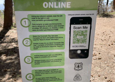 Image shows a sign giving instructions for purchasing a day pass online for hikers.