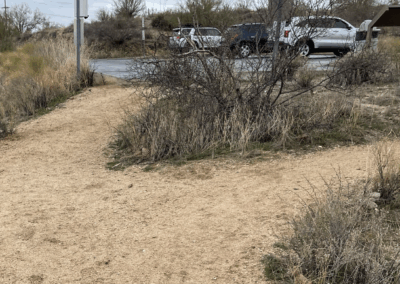 Image shows the intersection of two trails leaving a parking lot.
