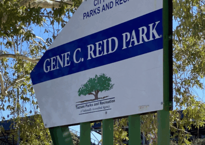 Image of a road sign pointing the way to Gene C. Reid Park at one of the park entrances.