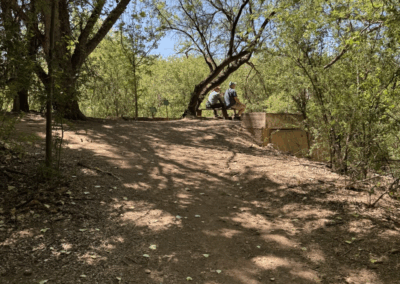 Image of two hikers sitting on a bench overlooking a scenic view of the Preserve.