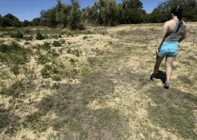 Image of a hiker crossing the wide-open field on the Pradera Trail