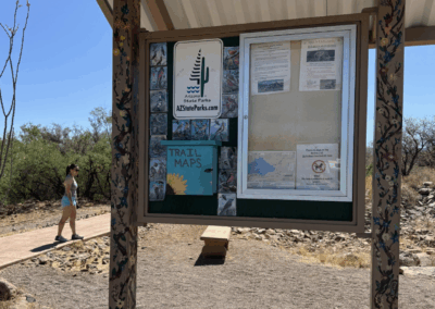 Image of a board at the trailhead providing information about the trail and the park.