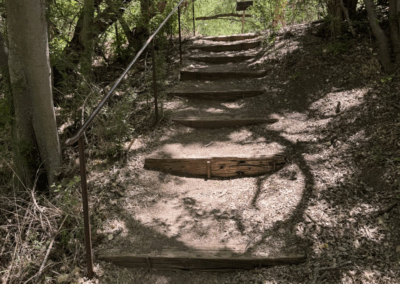 Image of stairs with a metal hand railing on the Railroad Trail.